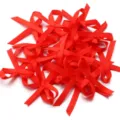 Vista ravvicinata di piccoli fiocchi in nastro di satin rosso per lavori artigianali. - 50 Pezzi/Confezione / Rosso