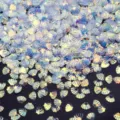 Primo piano dettagliato di paillettes a conchiglia iridescenti per nail art e fai da te. - 30g/Confezione (8mmx6mm) / Bianco trasparente lucentezza dorata
