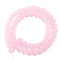 Vista dettagliata di perline rotonde in vetro rosa per la creazione di braccialetti. - Rosa