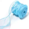 Detailed view of light blue iridescent organza ribbon showing wavy edge texture and glossy sheen. - Ice Sea Blue