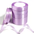 Rotoli di nastro in raso viola chiaro per confezioni regalo e decorazioni di nozze. - Viola