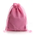 Dettaglio ravvicinato della borsa in morbido velluto rosa con coulisse per piccoli gioielli e trucchi. - Rosa
