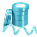 Primo piano di rotoli di nastro in raso azzurro lucido per confezioni regalo. - 1cm di Larghezza 25 Yard/Rotolo / Blu