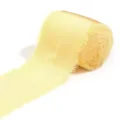 Primo piano di un rotolo di nastro di raso giallo chiaro con bordi sfrangiati e finitura. - Giallo imperiale