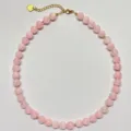 Dettaglio in primo piano della collana di perle di cristallo rosa con distanziatori oro. - Collana / 38+5cm / Rosa