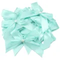 Primo piano di fiocchi in nastro di raso verde menta con perle a cuore bianche, accessorio fai da te. - Confezione da 10 Pezzi / Verde