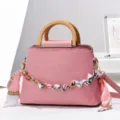 Sac à main rose texturé avec poignées en bois, chaîne métal et foulard soie décoratif. - Rose