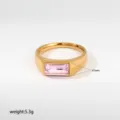 Primer plano detallado de un elegante anillo de sello de acero inoxidable dorado con gema rosa. - Estilo Sello Piedra Rosa Rectangular (446)