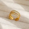 Vista detallada del elegante anillo abierto dorado con textura fina y buenos detalles. - Estilo Abierto Liso Multicapa