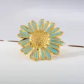 Detailopname van vergulde madelief ring met turquoise emaillen afwerking en glanzende textuur. - Goud