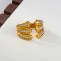 Gedetailleerd overzicht van de gouden roestvrijstalen open ring met zirkoonstenen. - Meerlaagse 3D-stijl / Goud