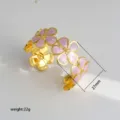 Gouden open manchetarmband met roze emaillen bloemdetails, elegant sieradenstuk. - 35