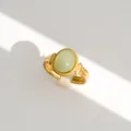 Detalle de un anillo abierto vintage de acero dorado con piedra verde clara y elegante. - Estilo Gema Verde Ovalada Elegante Vintage (391)