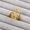 Primer plano de anillo abierto dorado, diseño geométrico minimalista, elegante joya expuesta. - Estilo Línea Multicapa Tridimensional Oro