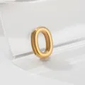 Gold stainless steel number 0 charm pendant detail shot, minimalist jewelry accessory display.