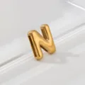 Close-up detail of shiny gold puffy letter N pendant showing smooth metallic gloss texture. - Letter N