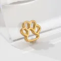 Close-up of a delicate gold-tone animal paw print metal charm pendant, premium design detail view. - Cat Paw