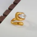 Detailopname van een stijlvolle 18k vergulde open ring met een sprankelende zirkoon. - Modern Geometrische Stijl / Goud
