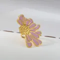 Close-up detail of a stylish stainless steel gold flower ring with purple enamel petals. - Gold