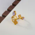 Gold-tone open ring featuring delicate floral charms and iridescent stone details, close-up. - Iridescent Stone Floral Style / Gold