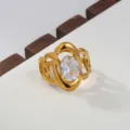 Close-up of a chic 18k gold stainless steel open ring with oval cubic zirconia and elegant cutout details. - Oval Stone Luxury Style / Gold