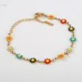 Nahaufnahme des bunten Blumenarmbands aus Edelstahl mit farbigen Gänseblümchen-Anhängern. - Bunte Blumenverzierung (C-1-102)