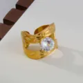 Detailed shot of gold stainless steel open ring with large cubic zirconia and leaf pattern. - Double Hollow Leaf Style / Gold