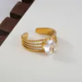 Detail shot of a multi-band gold stainless steel open ring featuring an oval cubic zirconia. - Oval Stone Multi-Layer Shank Style / Gold