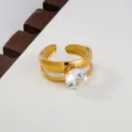 Close-up of a gold stainless steel open ring with a sparkling round cubic zirconia. - Minimalist Large Round Stone Style / Gold
