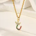 Primo piano dettagliato di una collana con ciondolo a lettera e corona con zirconi colorati. - Lettera U