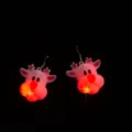 Primo piano dettagliato di orecchini natalizi a forma di renna luminosa LED al buio. - Orecchini con alce