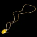 Gros plan détaillé du collier pendentif ampoule de Noël avec une chaîne de perles dorées. - Chaîne à billes / Jaune