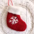 Roter Filz-Weihnachtsstrumpf als Anhänger mit weißem Schneeflocken-Muster für den Baum. - Roter Wollstiefel
