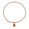Primo piano dettagliato della collana di perle rosse natalizie con ciondolo omino. - Collana Omino di Pan di Zenzero (Catena a Sfere) / Rosso