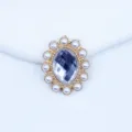 Close-up detail of oval acrylic rhinestone and pearl alloy button for DIY craft accessories. - White