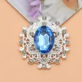 Vista detallada del botón de flor de estrás ovalado, con cristal azul brillante y pedrería clara. - Azul claro