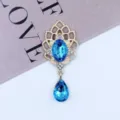 Detailed shot of gold alloy rhinestone acrylic pendant jewelry accessory with blue drop stones. - Lake Blue