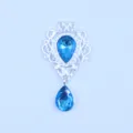 Detailopname van zilverkleurige legering druppel strass hanger DIY kledingaccessoire. - Meerblauw