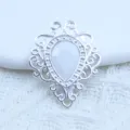Close-up van zilveren filigraan hanger met witte druppelsteen voor handgemaakte sieraden. - Steenwit