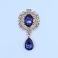 Vintage gold-tone alloy rhinestone brooch with blue oval crystal and teardrop pendant. - Navy Blue