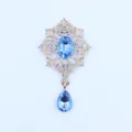 Detailopname van de gouden legering blauwe strass hanger bloem knop DIY kleding accessoire. - Lichtblauw