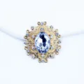 Close up detail of oval golden alloy rhinestone button for DIY hair accessories and crafts. - White
