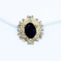 Close-up detail of the gold alloy oval rhinestone button featuring a central black gemstone. - Black