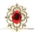 Close-up of gold alloy flower filigree base with red resin rhinestone for DIY jewelry crafts. - Gold Tone Ruby Red