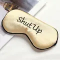 Champagne gold silk sleep eye mask with black embroidered Shut Up text variant. - Gold