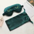 Dark green silk sleep mask with yellow eyelash embroidery and matching storage pouch set. - Dark Green