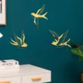 Close-up detail of golden mirror acrylic swallow wall stickers on a dark green wall, home decor. - Size S / Gold