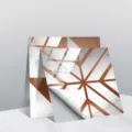 Close-up detail of self-adhesive marble tile sticker with copper geometric lines and peeling corner. - TS237