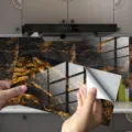 Close-up detail of marble texture tile sticker showing crystal film surface and peel-off backing. - DLS065