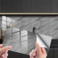 Detail view of grey marble self-adhesive tile sticker showing peel-and-stick backing layer. - DLS105 Crystal Film